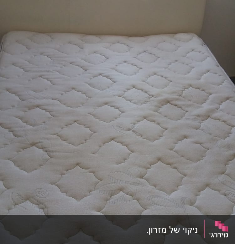 מזרן לבן עם דוגמה גיאומטרית על מיטה